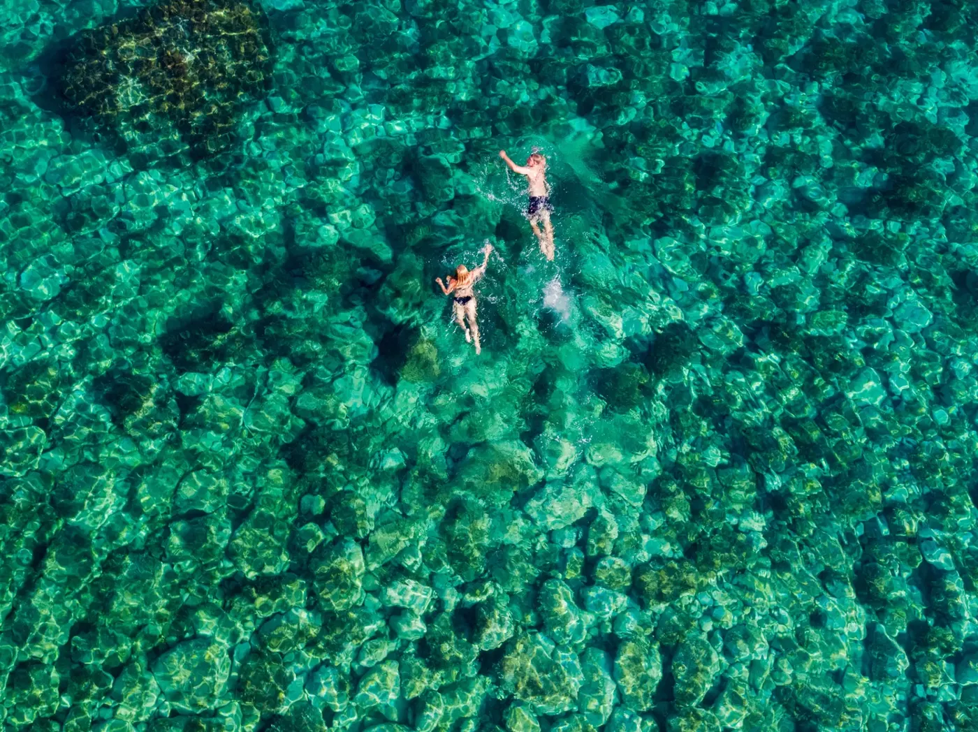 Zwei Schwimmer im klaren türkisfarbenen Wasser der Adria